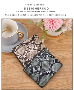 Detail of zippered wallets with snake skin texture in beige and grey-green tones