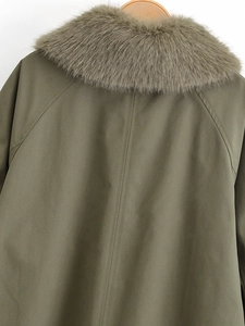 Close-up of olive green parka featuring a premium faux fur collar and quality back stitching