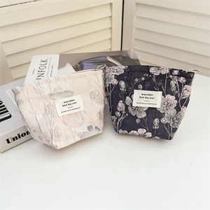 Detailed view of jacquard fabric texture and side ring on pink corduroy cosmetic bags