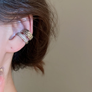 Gros plan de boucles d'oreilles clips en or martelé et argent serti de zircons