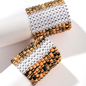 Detail of Halloween polymer clay bracelets with Spooky and Boo lettering on white display