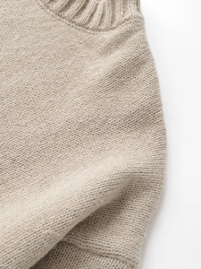 Close-up of oatmeal knit sweater showing premium wool texture and ribbed neckline detail
