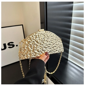 Macro detail of golden hammered texture on semi-circular metallic evening clutch bag