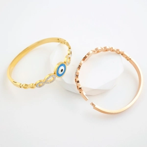 Gold and rose gold stainless steel bangles with evil eye and infinity diamond designs
