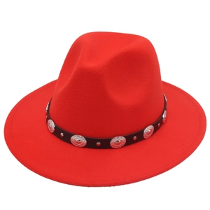 Détail d'un chapeau Fedora rouge en laine avec ceinture en cuir noir et clous argentés