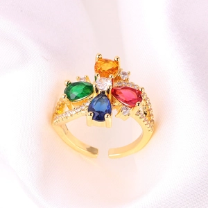 Dettaglio ravvicinato di anello dorato regolabile con zirconi colorati a forma di fiore