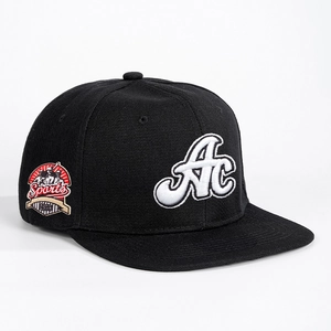 Retro black adjustable baseball cap featuring bold white AC embroidery and sports patch