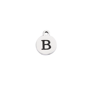 Macro detail of polished stainless steel round pendant with engraved black letter B