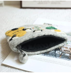 Detail of gray wool felt coin purse with bee embroidery and metal zipper closure