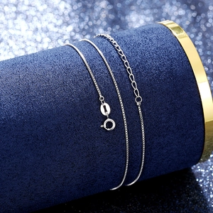 Polished silver box chain necklace with spring ring clasp on blue velvet display