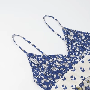 Detail of floral spaghetti strap dress showing pleated navy bodice and patchwork fabric