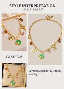 Detail view of gold chain necklace with sun star charms and green enamel coin pendant