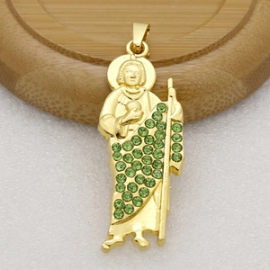 Vue macro d'un pendentif religieux doré serti de strass vert émeraude micro-incrustés