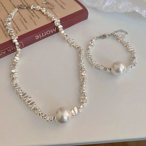 Detail of irregular silver beads necklace and bracelet set with large white pearls