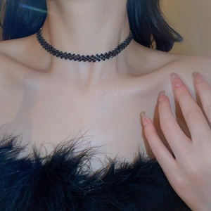 Detail of black rhinestone choker featuring a geometric diamond pattern on neck