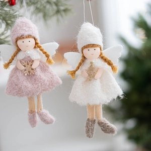 Pink and white Christmas plush angel ornaments hanging on a tree with soft bokeh background