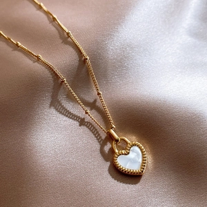 Double-sided gold heart necklace with white mother-of-pearl inlay on silk fabric