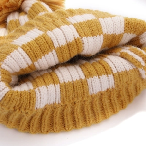 Gros plan sur la maille épaisse du bonnet à damier jaune et blanc pour enfants