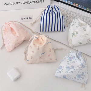 Flat lay showing various cartoon drawstring storage pouches with bear and flower patterns