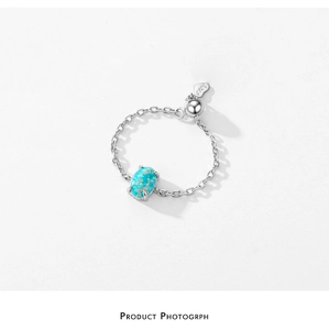 Detail of S925 sterling silver chain ring with oval blue fire opal and heart logo tag