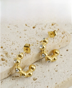 Vue détaillée des boucles d'oreilles en U en or 18 carats avec sertissage de zircons