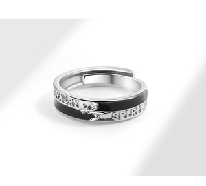 Detailed close-up of adjustable silver and black enamel ring with chivalry engraving