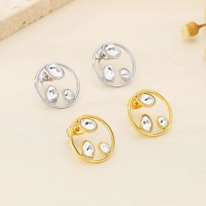 Detail of silver and gold hollow circle stud earrings featuring inset sparkling rhinestones