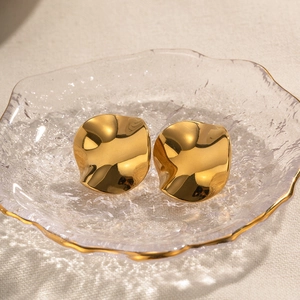 18k gold plated titanium steel earrings with wavy irregular texture in luxury dish