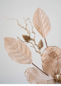 Macro detail of champagne artificial flower with velvet leaves and golden glitter pinecones