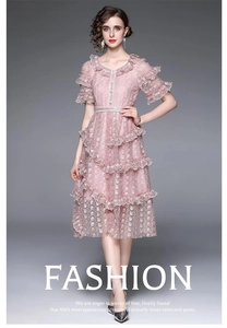 Broderies détaillées et couches de volants sur cette élégante robe midi rose d'été