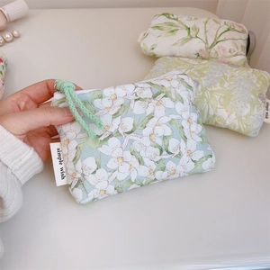 Detailed view of quilted cotton mini pouches with floral prints and woven zipper pulls
