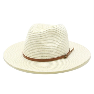 Macro detail of panama straw hat weave with brown leather band and bronze buckle