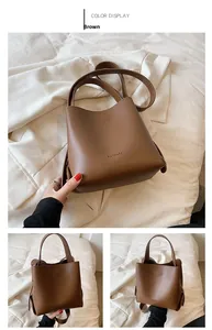 Detailed close-up of brown matte PU leather bucket bag with embossed brand logo