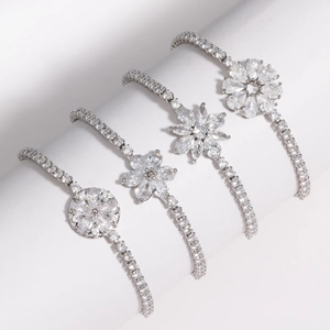 Détail de quatre bracelets fleurs en argent avec oxydes de zirconium sur support blanc
