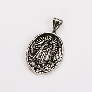 Macro shot of silver religious oval pendant featuring Virgin and Child with vintage finish