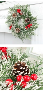 Détail d'une couronne de Noël avec aiguilles de pin, baies rouges et pommes de pin enneigées