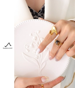 Detail of a gold fluid ring and a vintage stainless steel tiger eye stone ring
