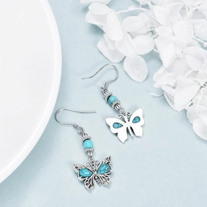 Detail view of bohemian turquoise butterfly earrings with vintage silver metal finish