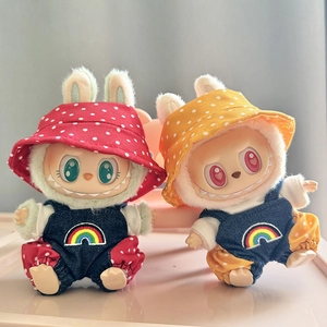 Close-up of doll clothes featuring denim overalls with rainbow embroidery and polka dot hats