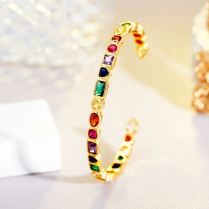 Elegant gold open bangle featuring multi-colored geometric zircons and rainbow gemstones