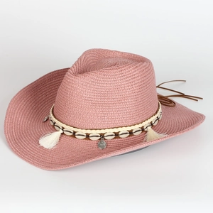 Detail of pink straw cowboy hat with bohemian shell decorations and white tassels