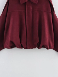 Detail shot of burgundy suede jacket featuring a classic lapel and shoulder epaulettes