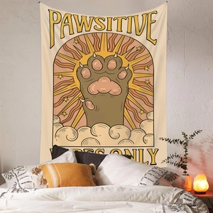 Detail of bohemian cat paw tapestry with Pawsitive Vibes Only text hanging in a cozy bedroom