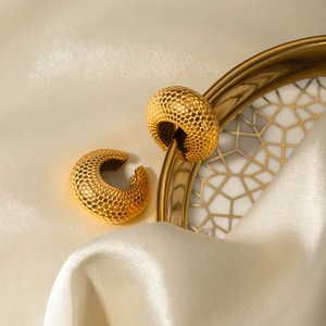 Detailed close-up of gold thick hoop earrings featuring unique honeycomb scale textures