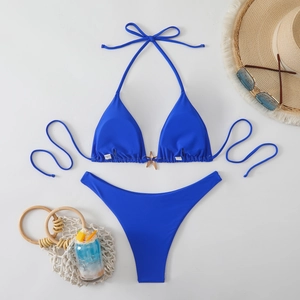 Flat lay of blue halter bikini with starfish charm and summer vacation accessories