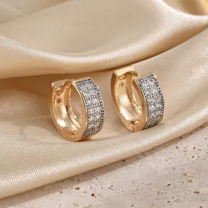 Detailed view of gold wide hoop earrings with micro-paved white cubic zirconia stones