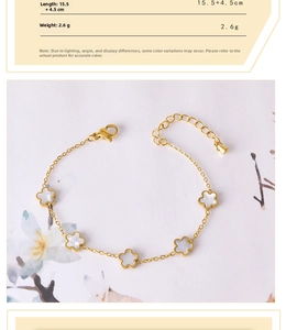 Detailed view of gold chain bracelet featuring five white shell flower charms and clasp