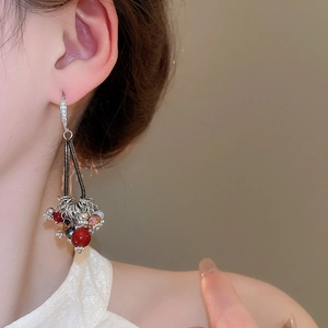 Gros plan de boucles d'oreilles à pompons avec perles en verre rouges et noires