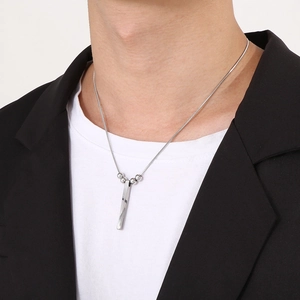 Detail of silver twisted bar necklace with small bead accents on male model
