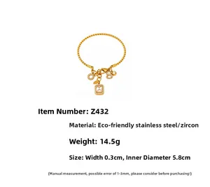 Dettaglio del bracciale a treccia placcato oro 18K con zirconi e ciondoli numerici